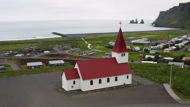 Aerial view of a red church in the coast of Iceland.