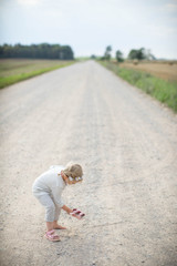Obraz premium Little girl on the road in countryside. Summer.