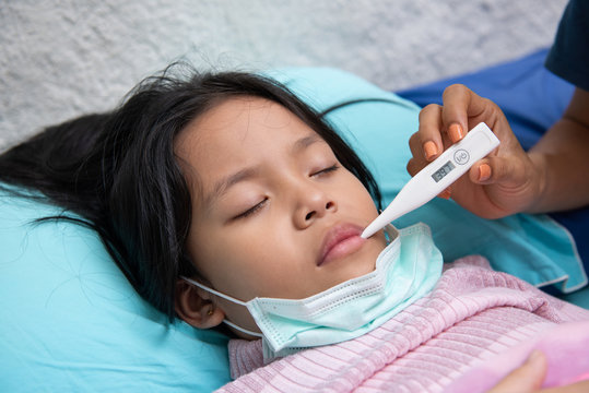 An Asian Girl Is Closing Her Eyes With A Woman's Hand Holding A Thermometer To The Mouth. May Have A Cough Until Sore Throat, Difficulty Swallowing, Colds, Flu Or Fever, Meet A Doctor At The Hospital