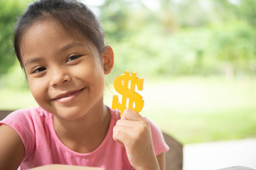Asian girl hold a golden symbol dollar and smile