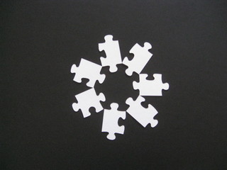 Piezas de puzzle de color blanco en forma de estrella de 7 puntas sobre fondo negro