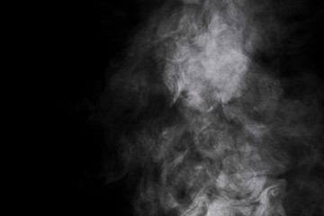 Aromatherapy. Essential oil aroma diffuser humidifier diffusing water articles in the air. Electric ultrasonic device emitting atomized water droplets against black background with copy space.