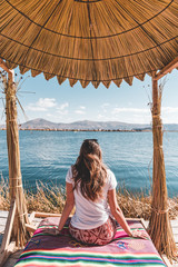 Femme assise devant lac typique