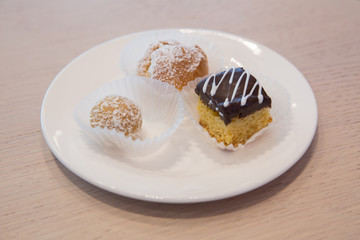 Slice of Three Chocolate Cake decorated with chocolate petal, on white plate, on white background . Cake inside the white plate .