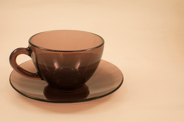 Brown mug on a saucer on a light background