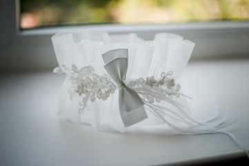White wedding garter on the white windowsill