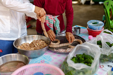 A picture of villagers cooking sausages for preserving food in the countryside.