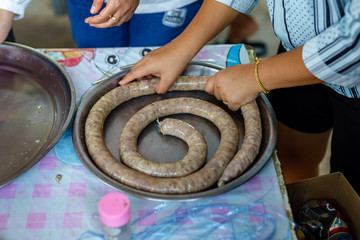 A picture of villagers cooking sausages for preserving food in the countryside.