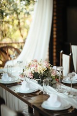 Dining table with floral centerpiece at wedding reception.
