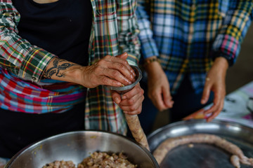 A picture of villagers cooking sausages for preserving food in the countryside.