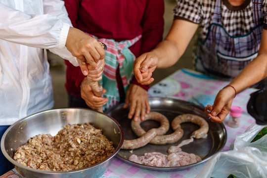 A picture of villagers cooking sausages for preserving food in the countryside.