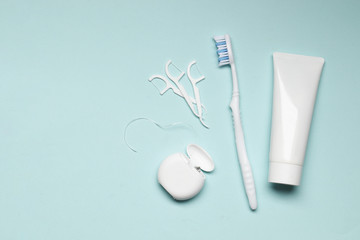 toothbrushes, toothpaste, dental floss on blue background. Dental care