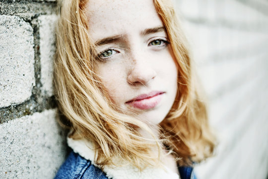 Portrait of girl leaning against a wall