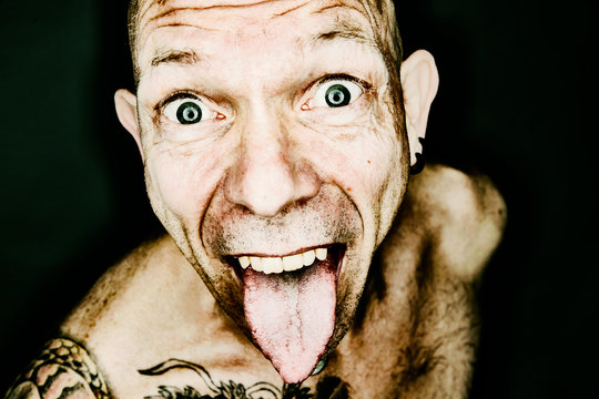 Portrait of staring man sticking out tongue