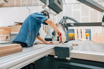 Carpenter working with saw in workshop