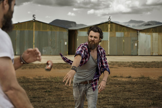 Man with full beard throwing beverage can to opponent