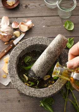 Preparing basil pesto with mortar