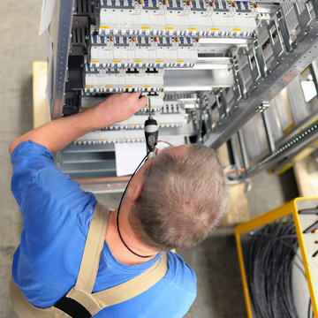 Worker in a switchboard construction factory