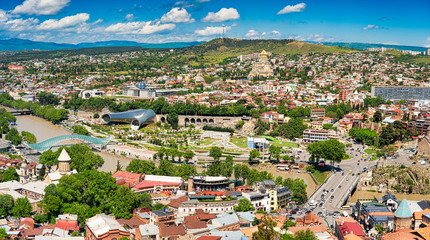 Fototapeta na wymiar Tbilisi, Georgia - May 9, 2017. Panorama of the central part of the ancient city and the main attractions of the capital of Georgia. Sunny day, blue sky with clouds.