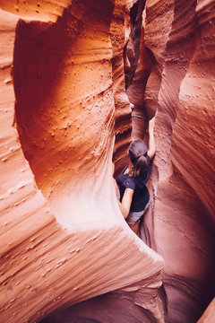 USA, Utah, Escalante, Peek-A-Boo and Spooky Slot Canyons, young woman climbing in gorge