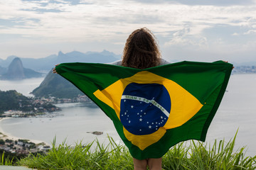 Brazil, woman with Brazilian flag on a viewpoint in Rio de Janeiro