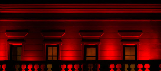 old building illuminated in red at night