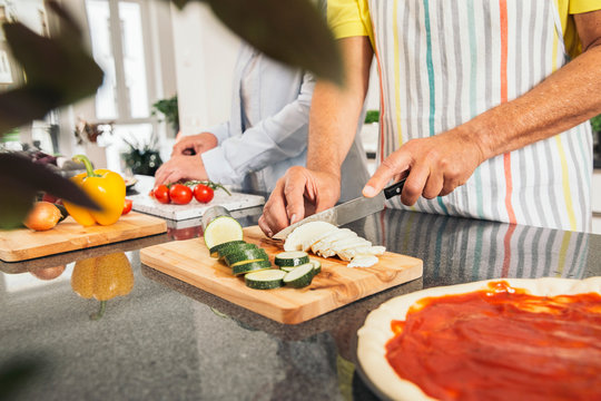 Couple Cutting Vegetables In The Kitchen