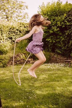 Girl jumping rope in garden