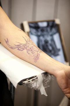 Forearm with stenciled tattoo in a tattoo studio