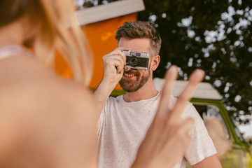 Man taking a photo of woman in front of van