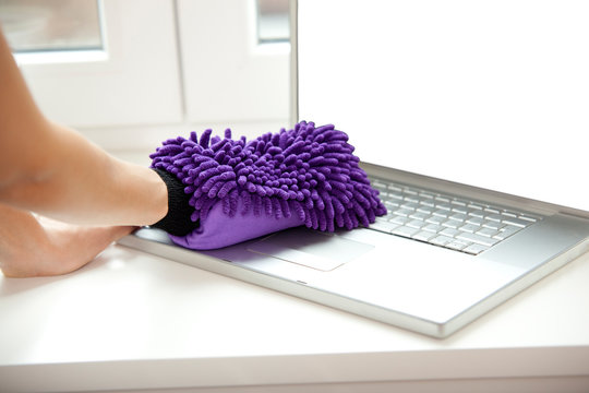 Woman cleansing laptop on windowsill