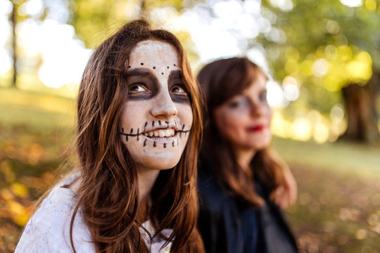 Portrait of masquerade girl at Halloween with her friend in the background