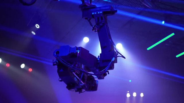 Video camera on the tap when shooting a television show. Live concert. The movement of the camera over the audience under the ceiling. Shooting from a height.