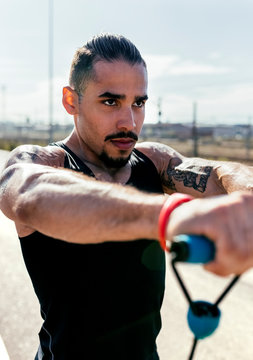 Portrait of young man exercising with expander