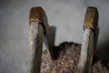 two old axes stuck in a wood block, close up, blurry background