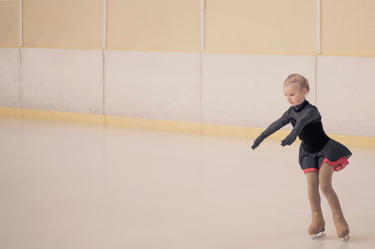 Young female, figure skater moving on ice rink