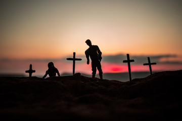 Silhouette some zombies on the cemetery walking around at sunset. Selective focus