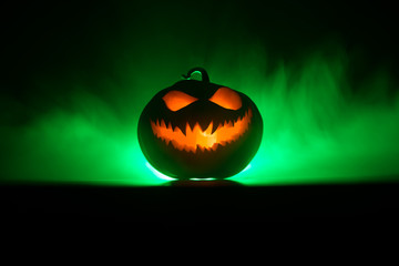 Halloween pumpkin smile and scary eyes for party night. Close up view of scary Halloween pumpkin with eyes glowing inside at black background