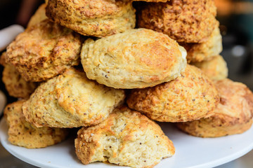 Freshly baked homemade English scones displayed as a pyramid, available for sale at a café in London, selective focus