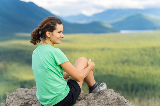Hiker looking at green hills and lake from the edge in Washington