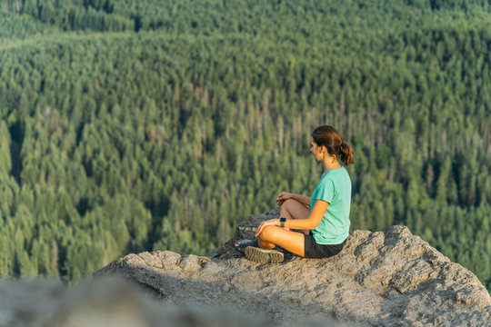 Hiker looking at green hills and lake from the edge in Washington