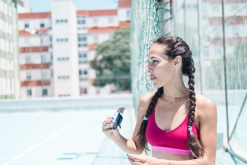 Colorful image of female athlete eating a recovery bar on court