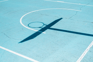 Shadow of a basketball hoop on colorful court