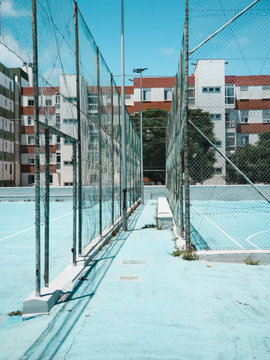 High ball stop fences separating basketball courts