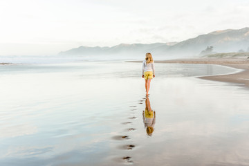 Footprints in sand from tween girl walking on beach