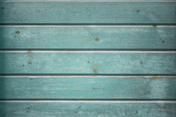 Vintage horizontal wood background  texture with peeling paint, pastel wood planks texture background with knots and cracks in cool blue and green tones.