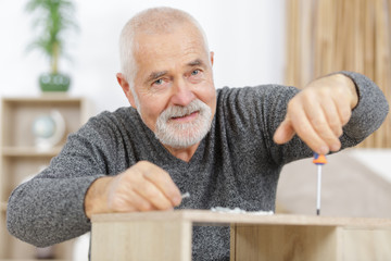 a mature man making furniture