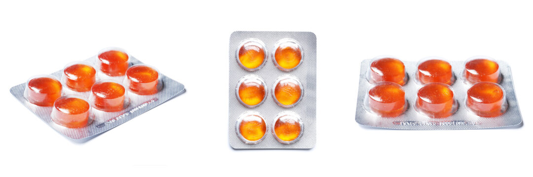 Orange Blisters with color cough drops isolated on a white background.