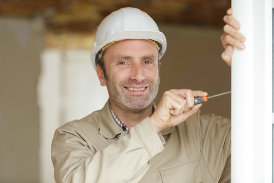 A Happy Male Builder During Door Installation