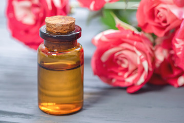 Rose petal flower essential oil in a bottle close up concept.
